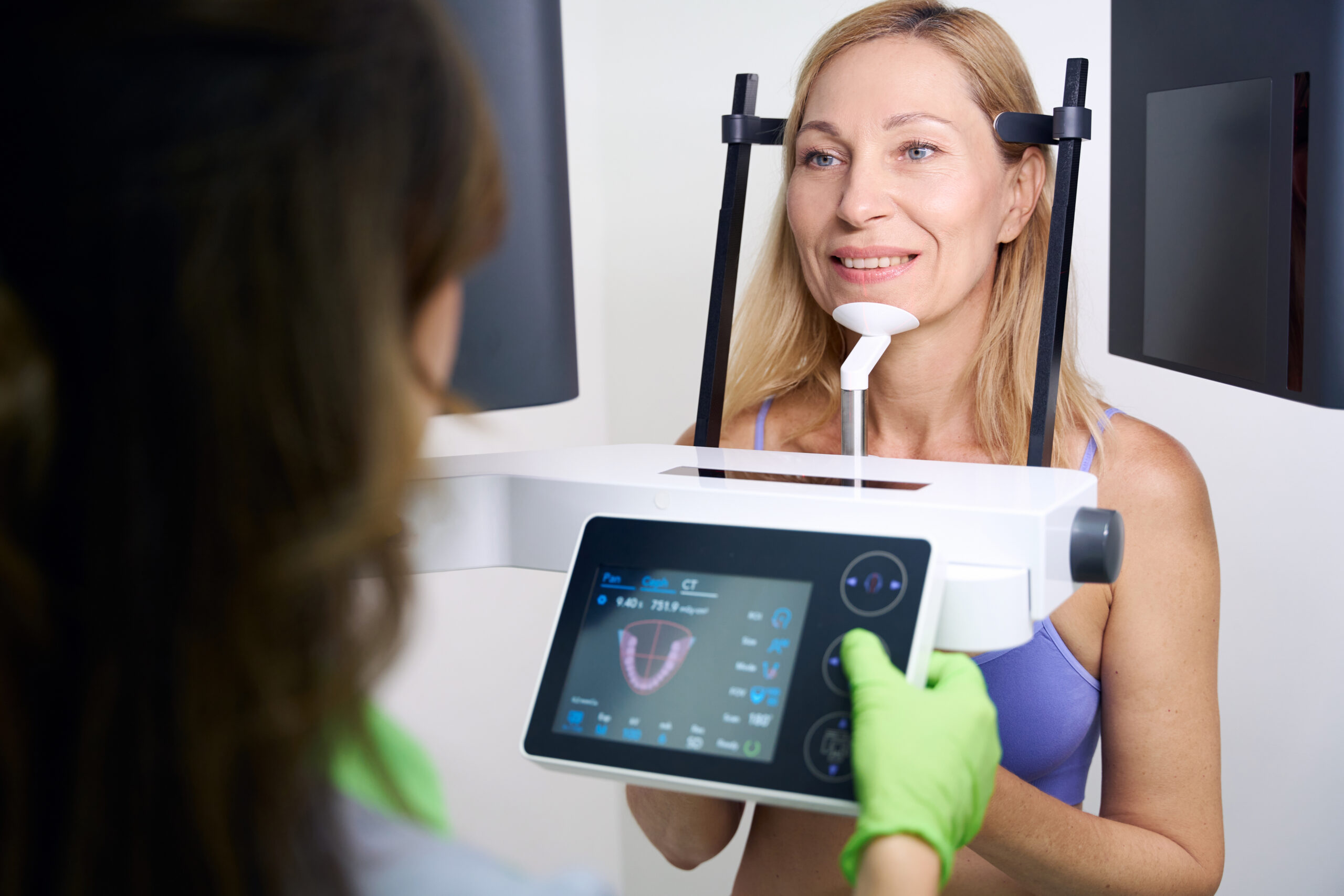 Patient undergoing dental cone-beam computed tomography carried out by experienced radiographic technologist